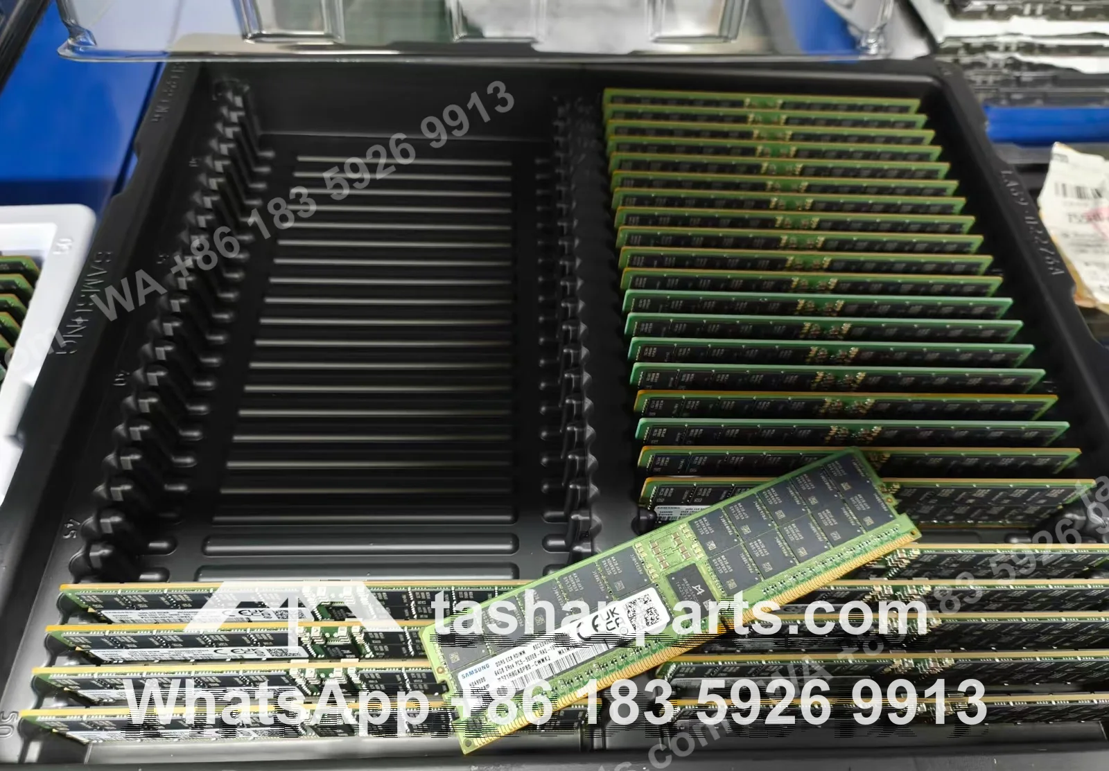 A Samsung anti-static tray of 64 GB DDR5 RDIMMs with one module held up, its part number legible